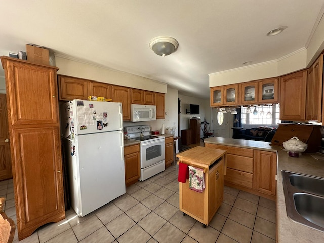 kitchen featuring a center island, light tile patterned floors, sink, crown molding, and white appliances