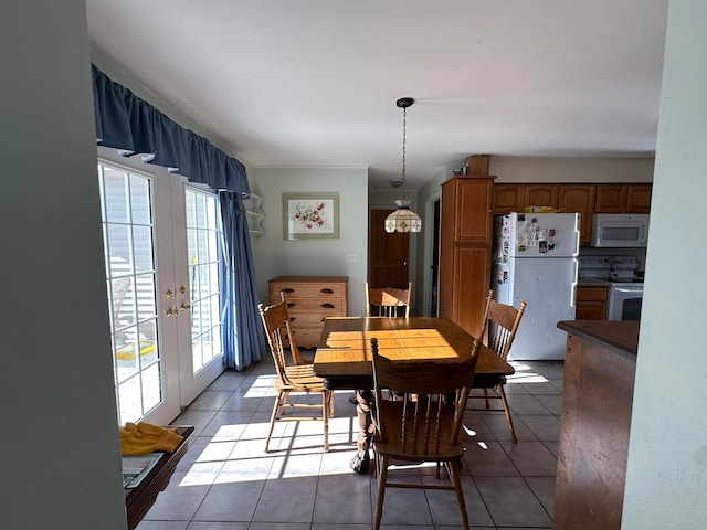 dining room featuring french doors, a healthy amount of sunlight, crown molding, and light tile patterned flooring