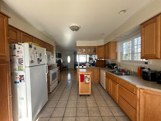 kitchen with a center island, sink, white appliances, and light tile patterned floors