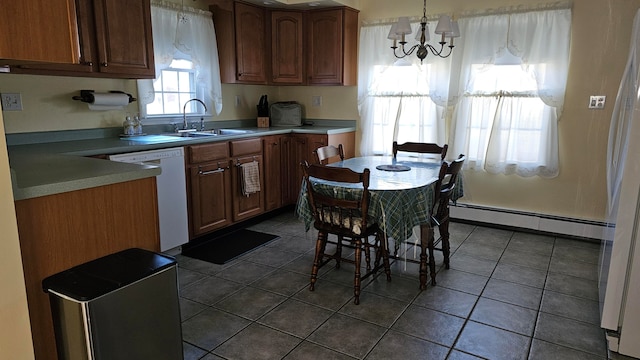 kitchen featuring a baseboard heating unit, white dishwasher, sink, dark tile patterned floors, and decorative light fixtures