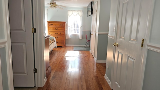 bedroom featuring ceiling fan, light wood-type flooring, and crown molding