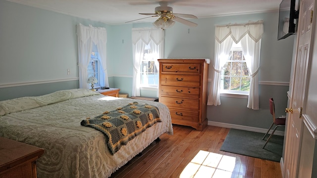 bedroom with light hardwood / wood-style floors, ceiling fan, and crown molding