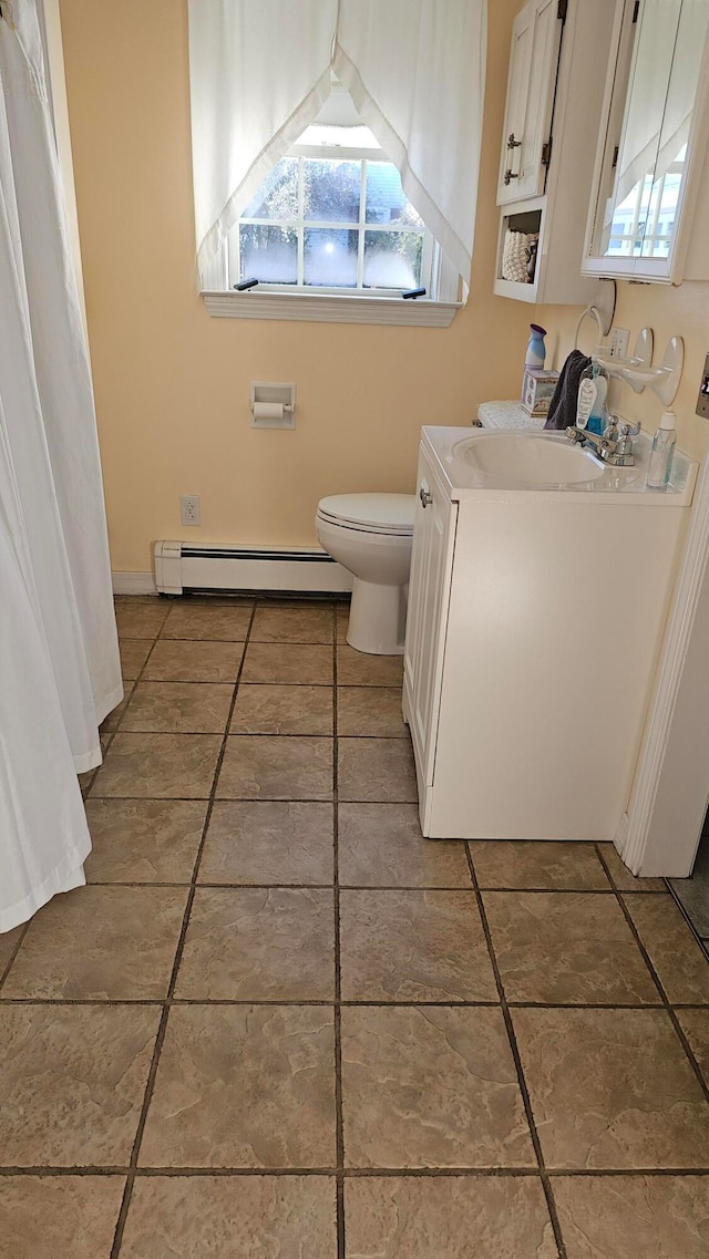 bathroom featuring baseboard heating, tile patterned flooring, vanity, and toilet