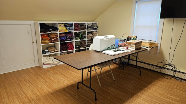 home office featuring vaulted ceiling, baseboard heating, and wood-type flooring