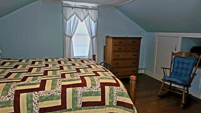 bedroom with a baseboard heating unit, dark hardwood / wood-style flooring, and vaulted ceiling