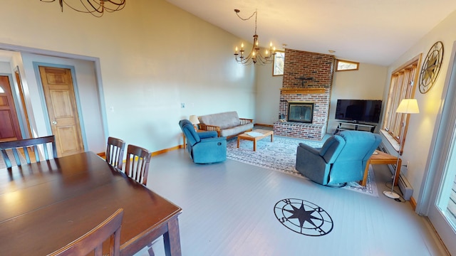 living room with a fireplace, hardwood / wood-style floors, vaulted ceiling, and an inviting chandelier