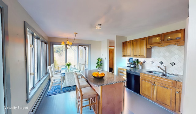 kitchen with a kitchen island, decorative light fixtures, black dishwasher, decorative backsplash, and sink