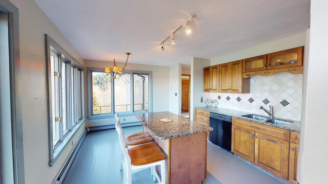 kitchen with a center island, black dishwasher, sink, a breakfast bar area, and decorative light fixtures