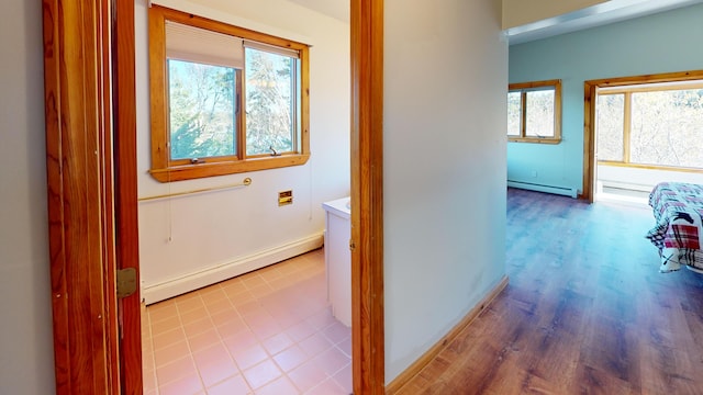 hallway with a baseboard radiator and light hardwood / wood-style flooring