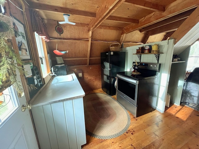 kitchen featuring stainless steel electric range oven, ceiling fan, sink, black refrigerator, and light wood-type flooring