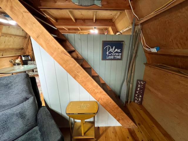 staircase with hardwood / wood-style floors and wood walls