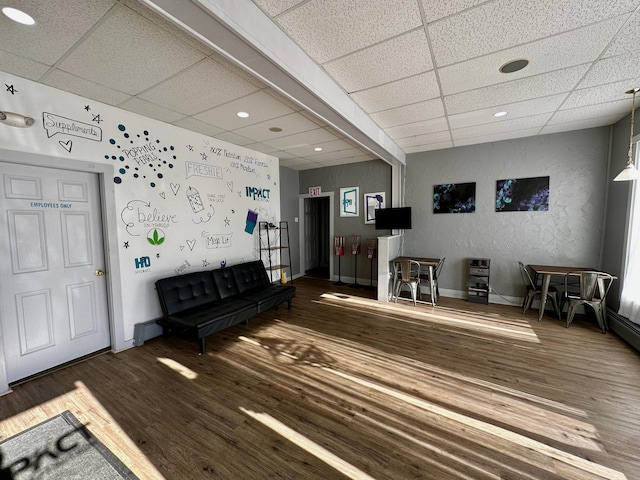 interior space featuring wood-type flooring and a drop ceiling