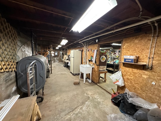 basement with sink and white refrigerator