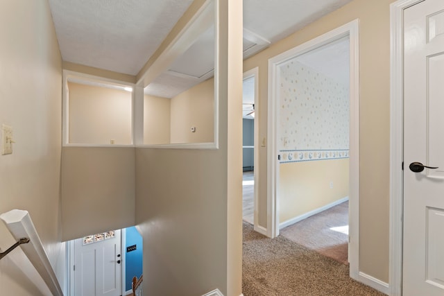 corridor with carpet floors and a textured ceiling