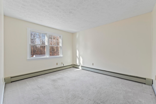 carpeted empty room featuring a baseboard heating unit and a textured ceiling