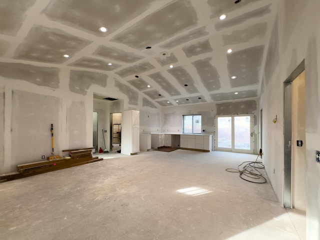 unfurnished living room featuring high vaulted ceiling