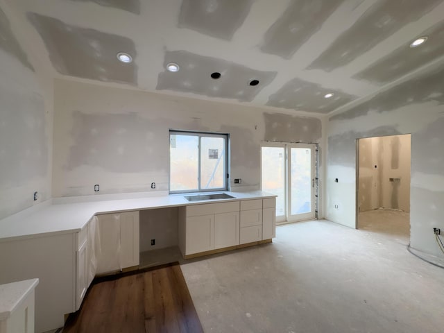 kitchen with white cabinetry, sink, and light hardwood / wood-style floors