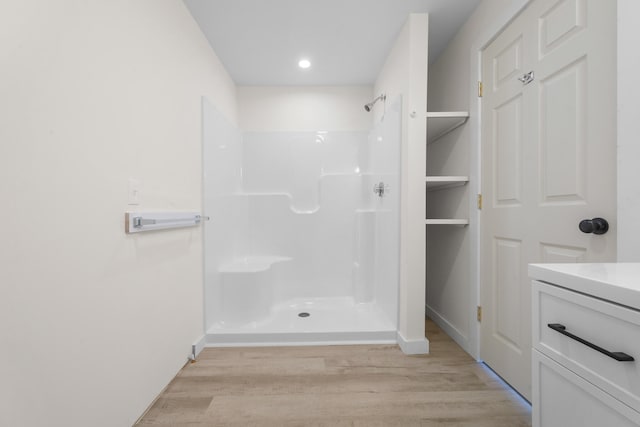 bathroom featuring hardwood / wood-style floors, vanity, and a shower