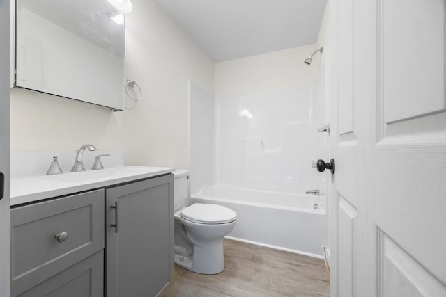 full bathroom with shower / bathing tub combination, wood-type flooring, toilet, and vanity