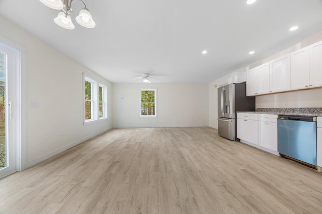 kitchen with ceiling fan with notable chandelier, light hardwood / wood-style flooring, hanging light fixtures, white cabinetry, and appliances with stainless steel finishes