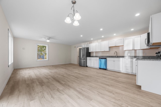 kitchen featuring sink, appliances with stainless steel finishes, hanging light fixtures, white cabinets, and light wood-type flooring