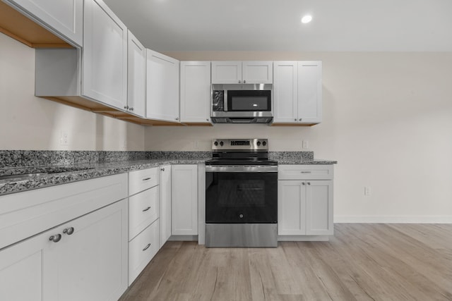 kitchen with light wood-type flooring, white cabinets, and stainless steel appliances