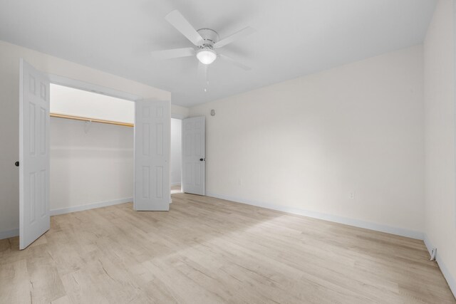 unfurnished bedroom featuring light hardwood / wood-style floors, ceiling fan, and a closet