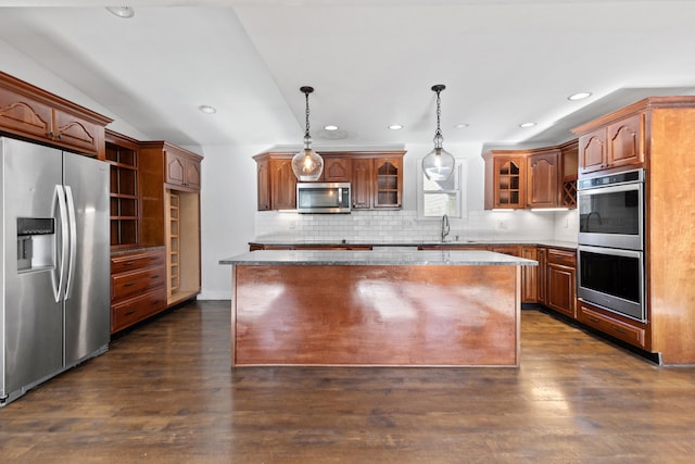 kitchen with sink, a center island, hanging light fixtures, dark hardwood / wood-style flooring, and appliances with stainless steel finishes