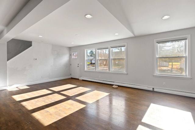 unfurnished living room with dark wood-type flooring and a baseboard radiator