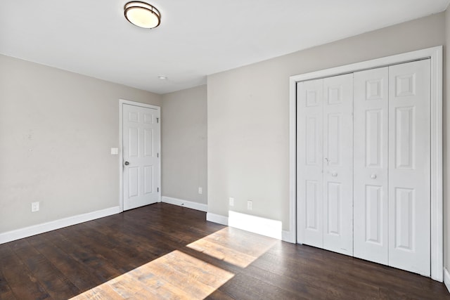 unfurnished bedroom featuring dark wood-type flooring and a closet