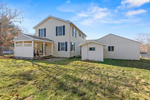 back of house featuring a yard and a storage unit