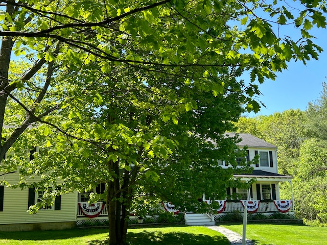 view of property hidden behind natural elements featuring a front lawn