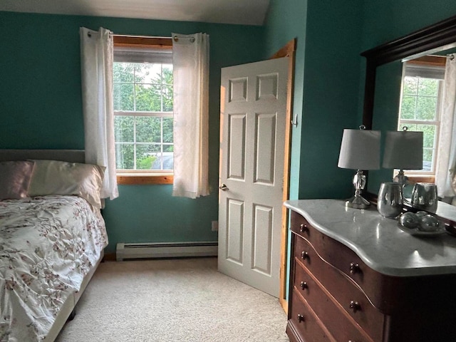 bedroom with baseboard heating and light carpet