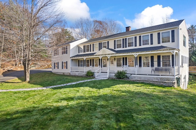 colonial home with a porch and a front yard