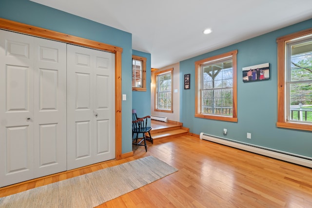 foyer entrance featuring light hardwood / wood-style flooring and a baseboard heating unit