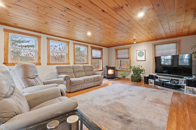 living room featuring a wood stove, a wealth of natural light, wood ceiling, and wood-type flooring