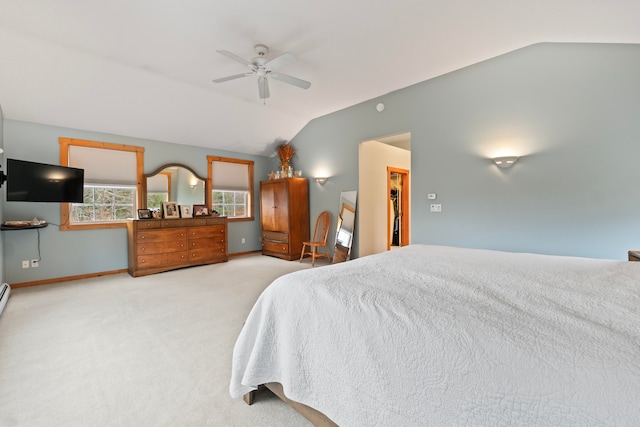 carpeted bedroom featuring a walk in closet, ceiling fan, a closet, and vaulted ceiling