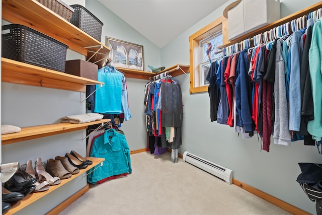 walk in closet featuring light carpet, vaulted ceiling, and a baseboard heating unit