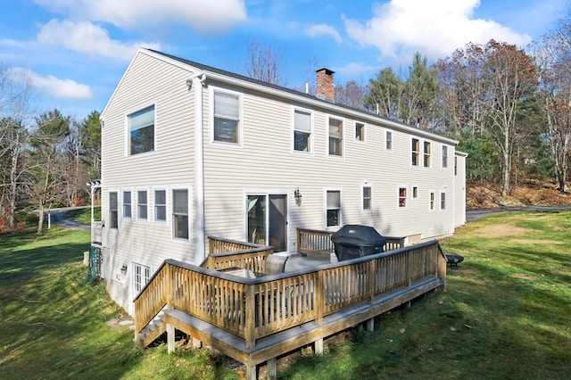 rear view of property featuring a lawn and a wooden deck