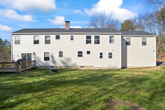 back of house featuring a lawn and a wooden deck