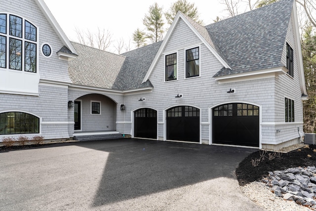 view of front of house featuring a garage and cooling unit