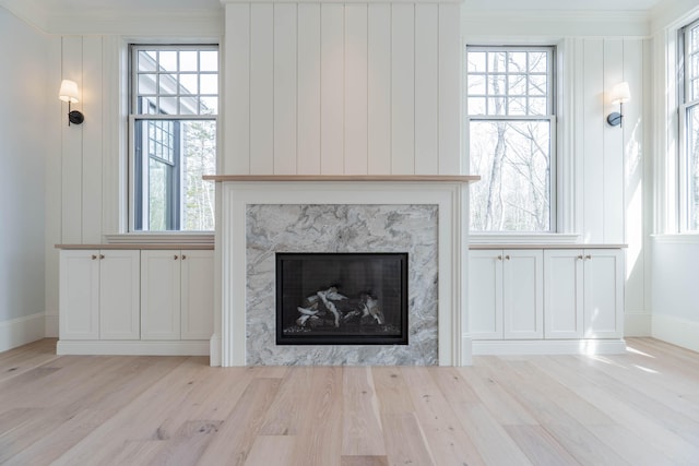 details with ornamental molding, hardwood / wood-style floors, and a premium fireplace