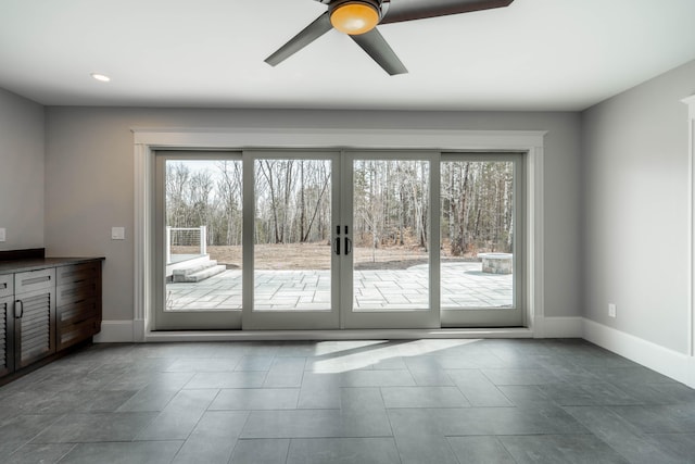 doorway featuring dark tile patterned floors, ceiling fan, french doors, and a healthy amount of sunlight