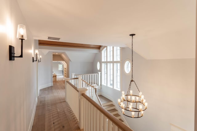 hallway featuring an inviting chandelier, vaulted ceiling, and hardwood / wood-style flooring