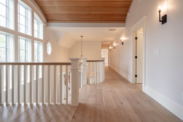 hallway with wood ceiling, lofted ceiling, and light hardwood / wood-style floors