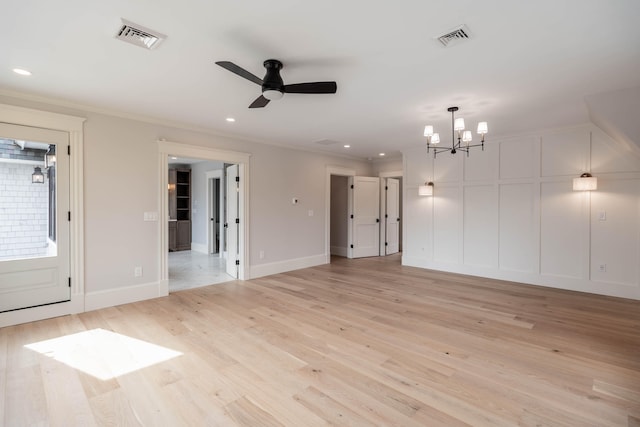 empty room featuring ceiling fan with notable chandelier, light hardwood / wood-style flooring, and crown molding