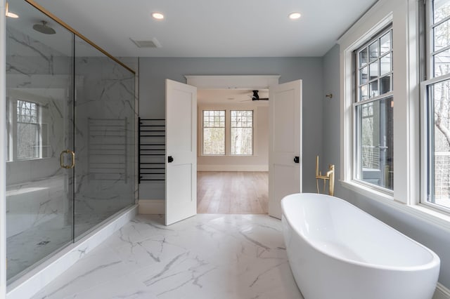 bathroom featuring independent shower and bath, a wealth of natural light, wood-type flooring, and ceiling fan