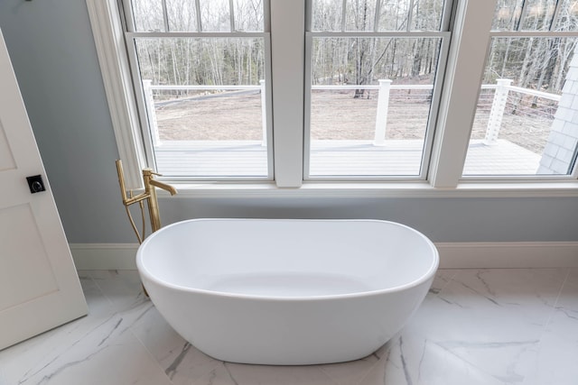 bathroom featuring a tub to relax in and plenty of natural light