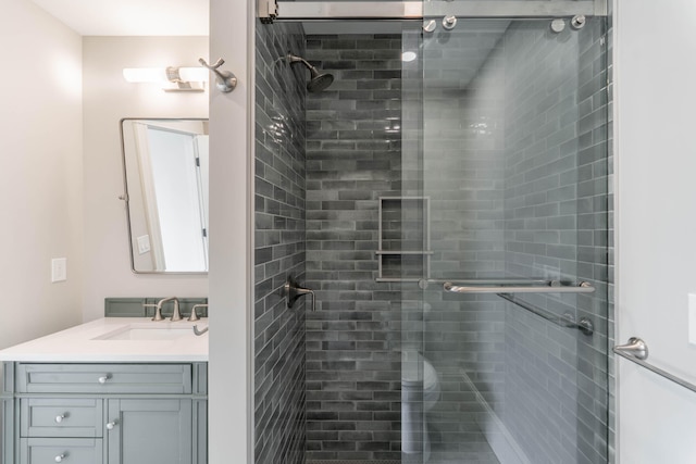 bathroom featuring vanity and a shower with door