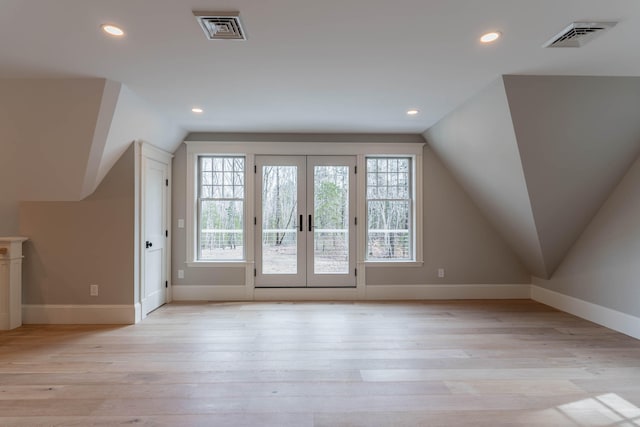 bonus room featuring french doors, light hardwood / wood-style flooring, and vaulted ceiling